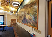 a countertop runs along the wall with a mural above it. Main entrances are on either side of the countertop.